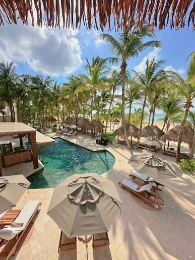 The pool, palms and beach at El Dorado Maroma