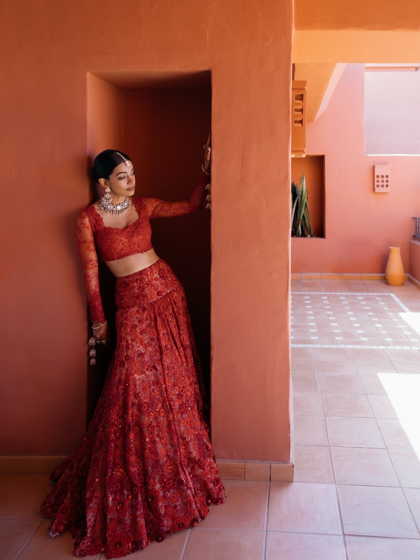 A bride in red beside the terracotta architecture of The Ritz-Carlton, Abama