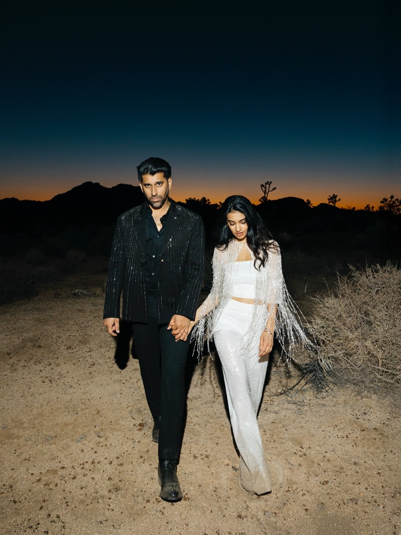 A couple walking together beneath a deep blue evening sky
