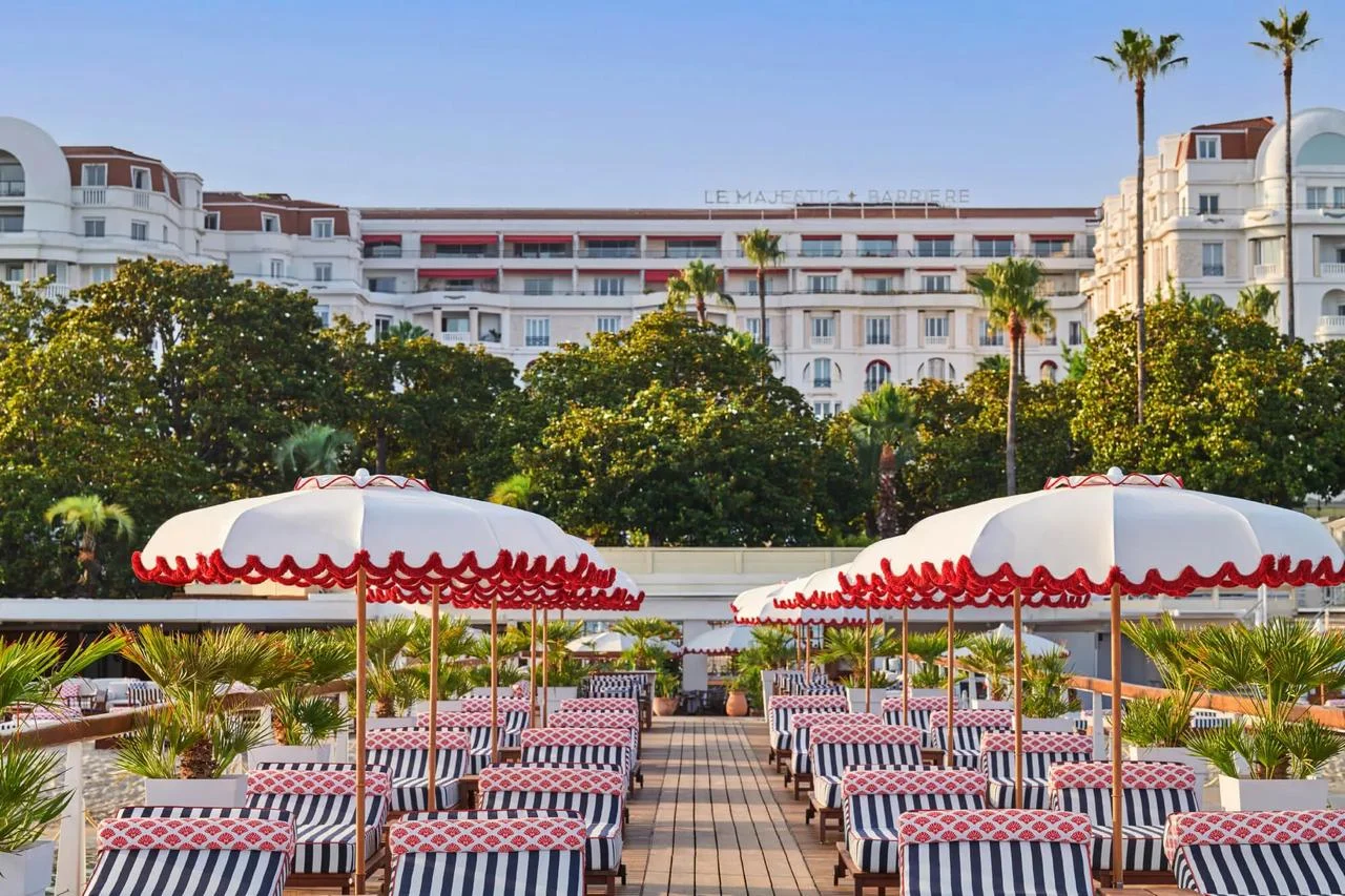 Hôtel Barrière Le Majestic Cannes behind its striped terrace
