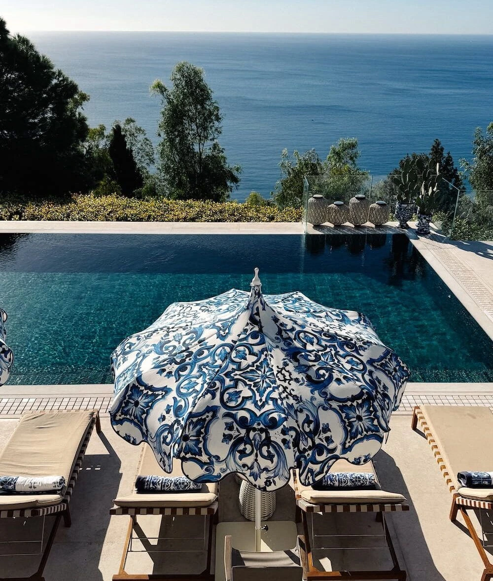 Blue and white parasol beside the pool and sea at San Domenico Palace in Taormina