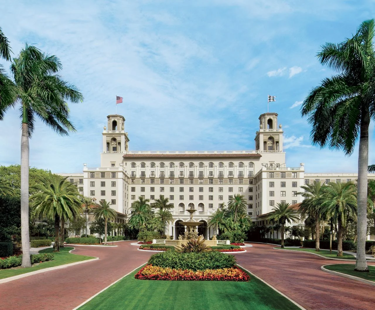 The Breakers Palm Beach framed by palms and its oceanfront drive